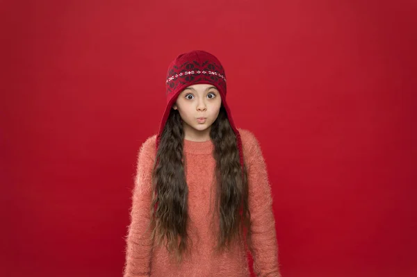 На улице холодно. Зимний наряд. Симпатичная модель наслаждается зимним стилем. Малыш носит вязаную шляпу. Не замерзни. Маленькая девочка зимняя мода аксессуар. Маленький ребенок длинные волосы носить шляпу бордовый фон — стоковое фото