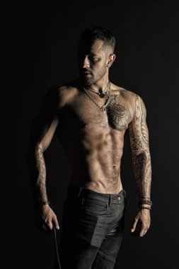 Güçlü gövde sakallı adam. Dövmeli kol ve göğüs olan adam. Seksi göbek ile dövme modeli. Sporcu ya da atlet moda kot pantolon. Fitness ve spor vintage filtre ile ilgilenmek