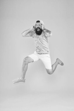 Mutlu müzik. Mutlu hipster sarı arka planda müzik atlama. Sakallı adam mutlu yüz gülümseme ile kulaklıklar oynarken şarkı zevk. Mutlu eğlenceli ve iyimser