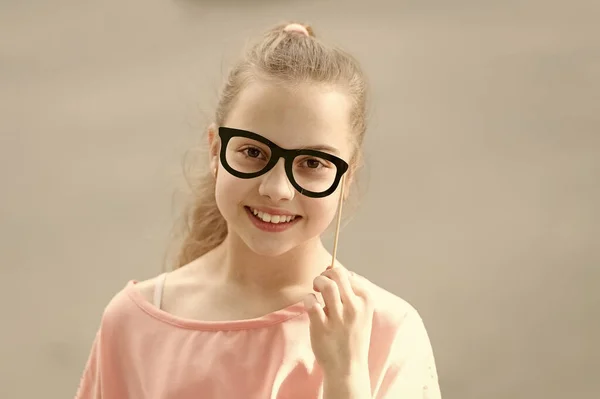 Felicidad alegría y concepto divertido. Cabello largo niño sonrisa feliz cara. Vacaciones de verano. Diversión y humor. Niña despreocupada divirtiéndose. Día internacional de los niños. Bonito día para divertirse con accesorios de cabina de fotos — Foto de Stock