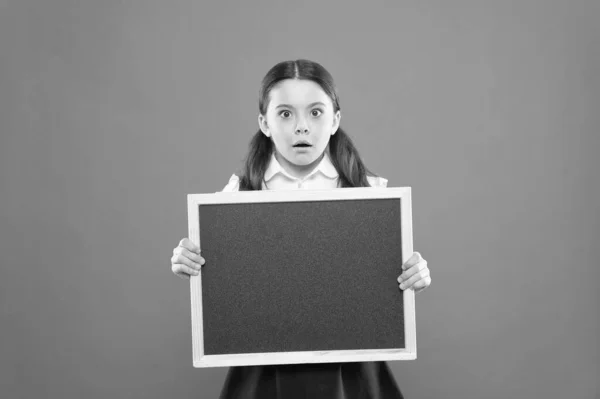 Your text here. information. write hometask. back to school. teachers day. 1 september. small girl demonstrate announcement. surprised small school girl with chalkboard. blackboard for copy space — Stock Photo, Image