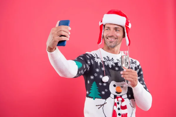 Imprezowe selfie. Człowiek z brodą robi sobie selfie smartfonem. Szczęśliwy facet uśmiecha się do aparatu selfie w telefonie komórkowym. Sesja selfie w uroczystym stylu. Zdrowie szczęśliwego Nowego Roku. Wesołych Świąt — Zdjęcie stockowe