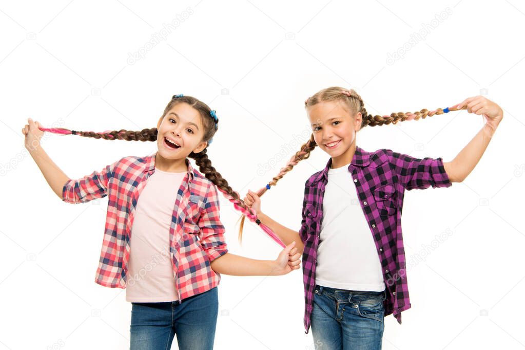 Such a long hair. Happy little girls wear plaited hair. Cute small childred hold hair braids. Luxurious hair extensions. Hairdressing salon for kids