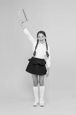 Bilgi konusunda heyecanlı. mutlu kız dizüstü ile çok çalışma. okuma ve yazma. kitap ile küçük kız çocuk. edebiyat dersi. çocuk edebiyatı. Okula geri dön. Kitap mağazasında veya kütüphanede öğrenci