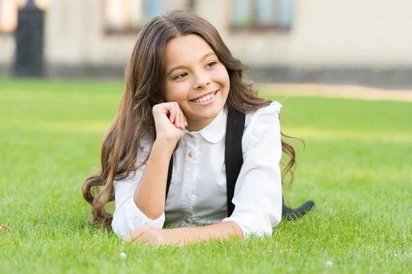 Le vacanze sono divertenti. Buon bambino piccolo godere le vacanze scolastiche. La bambina si rilassa sull'erba verde durante le vacanze. Giornata libera. Vacanze o vacanze scolastiche. Vacanza. — Foto Stock