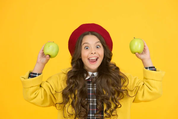 Яблука вітамінна закуска. Дівчина мила довге кучеряве волосся тримає яблука. Дитяча дівчинка емоційно усміхнений вираз обличчя. Смачно і смачно. Сезон збору врожаю. Дитяче щасливе обличчя тримайте яблука. Концепція здорової їжі — стокове фото