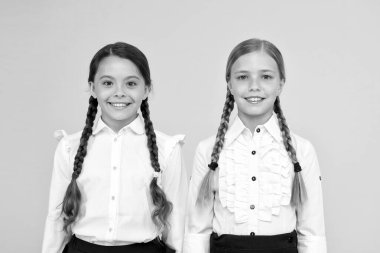 Mükemmel öğrenciler. Sarı arka planda kızlar mükemmel üniforma kıyafeti. Okul kurallarına göre. Sınıf arkadaşları düzenli öğrenciler. Yetenekli çocuklar için eğitim programı. En iyi öğrenciler ödülü. Her şeyi doğru yapma