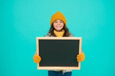 Kış eğlencesi ve aktiviteleri. Sunum konsepti. Gülümseyen kız, kışlık boş karatahta fotokopi odası giyer. Yeni bilgiler. Çocuklar için bilgi. İyi tatiller. Bilgiyi göster