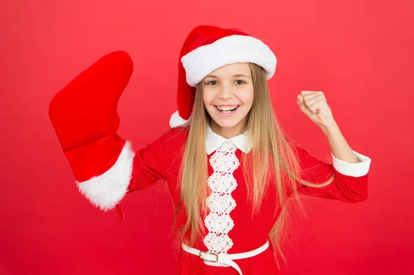 Enthousiaste. Fête de Noël. Vacances d'hiver. Ambiance ludique. Idées de célébration de Noël. Costume de Père Noël enfant tenir bas. Joyeux visage souriant. Bébé émotionnel. Bonnes vibrations. Concept de positivité — Photo