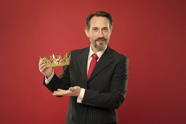 El hombre barbudo de traje sostiene el símbolo de la corona dorada de la monarquía. Conviértete en rey. Premio y logro. Sentir superioridad. Ser humano superior. Atributo de la monarquía. Monarquía tradiciones familiares — Foto de Stock