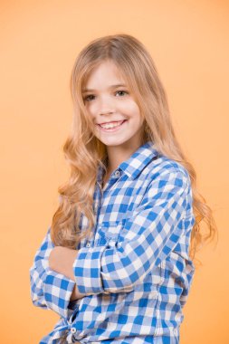 Sarı uzun saçlı, mavi gömlekli çocuk gülümsüyor.