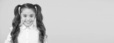 Okula çocukluk günleri. Mutlu küçük çocuk sarı arka planla okula dönüyor. Çocukluk bakımı ve eğitimi. Çocukluk anıları yaratmak. Çocukluk kavramı, kopyalama alanı