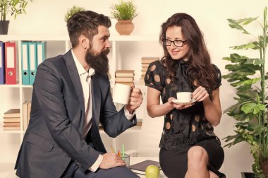 Kahvaltıda. İş ortakları ofiste kahvaltı yapıyor. Kahvaltıda çay ya da kahve içen iki iş arkadaşı. Şirket yöneticileri kahvaltı saatinde konuşuyor.