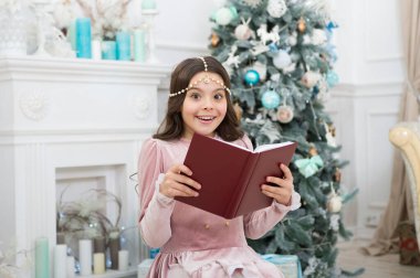 Yeni yıl için ne hayal ediyorsun? Mutlu kız Noel ağacında fantezi kitabı tutuyor. Noel çocuğu fantezi hikayeleri okur. Çocukların fantezi ve hayal gücü. Peri masalı