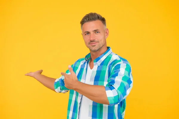 Saldi estivi qui. sexy uomo giallo sfondo. uomo maturo faccia rasata. tizio sorridente che punta il dito, spazio per la copia. camicia primavera modello maschile. presentazione del prodotto. merci per gli uomini. sconti stagionali — Foto Stock