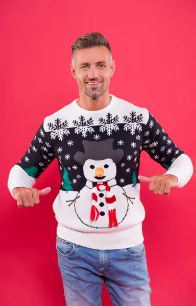 Karácsonyi tulajdonság. Jóképű ember téli pulóvert visel hóemberrel. Hópelyhek mintája. Kötött ruha koncepció. Vicces pulcsi. Férfiruha. Hagyományos pulóver az ünnepekre. Mosolygós érett srác szórakozás — Stock Fotó