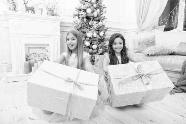 Счастливые маленькие сестры празднуют зимний праздник. С Новым годом. Рождественское время. Семья. Милые маленькие девочки с рождественским подарком. Подарки на Рождество. Рождественское веселье огромные подарки — стоковое фото