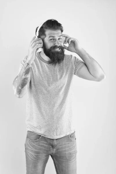 Liberté allant sans fil vous offre est inégalée. Hipster heureux en utilisant des écouteurs sans fil modernes. Casque sans fil conçu pour offrir un son propre. Homme barbu écouter de la musique gadget sans fil — Photo