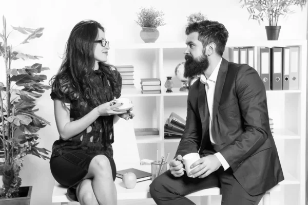 Встреча экспертов. Чувственная женщина и бородатый мужчина встречаются за чашкой чая во время рабочего перерыва. Менеджеры компании проводят неформальные деловые встречи в офисе. Деловое обсуждение в зале заседаний — стоковое фото