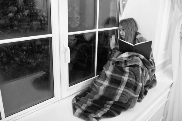 从前。小女孩喜欢读圣诞故事。小孩在圣诞前夜看书。用格子包裹的小读者坐在窗台上。儿童画册。神奇的圣诞精神 — 图库照片