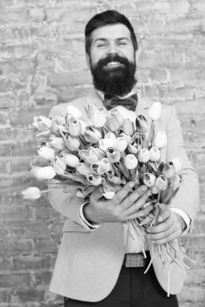 Romantic man with flowers. Romantic gift. Macho getting ready romantic date. Tulips for sweetheart. Man well groomed wear blue tuxedo bow tie hold flowers bouquet. Waiting for his girlfriend