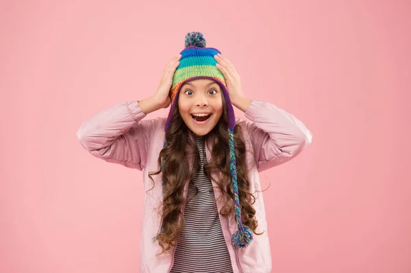 Lekfullt humör. Trendig snygg accessoar. Barn hattar för vintersäsongen. Tillbehörsskydd huvud. Underbara små barnkläder stickad accessoar. Söt liten flicka med mode tillbehör rosa bakgrund — Stockfoto