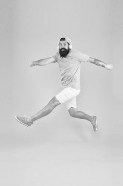 Eğlence için enerjik ve neşeli müzik. Enerjik hipster sarı arka plan üzerinde yüksek atlama. Orta havada sakallı adam. Enerjik müziğin tadını çıkaran acımasız adam. Aktif ve enerjik