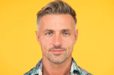 Erkek doğal güzelliği. Seksi adam sarı arka plan. Gerçek bir erkeğin portresi. Olgun, tıraşsız bir adam. Gülümseyen adam hoş bir yüz. Erkek derisi ve yüz bakımı. Kendine güvenen manken. berber salonu hizmetleri