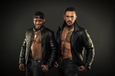 Erkeklik ve vahşeti kavramı. Seksi kas torsolar erkeklerle vahşice bak. Maço kas torsolar ile deri ceketler, koyu arka plan çekici görünüyorsun. Erkekler gülümseyen yüzler kıl ile üzerinde