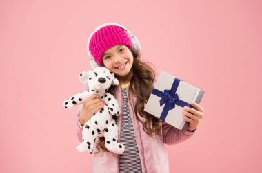 Şirin köpek oyuncağı çabucak onun en sevdiği arkadaşı oldu. Mutlu çocuk pembe arka planda oyuncak hediye aldı. Küçük kız oyuncak ve hediye kutusuna sarılıyor. Doğum günü hediyesi ya da hediye. Sadece hayal gücü için bir oyuncak.