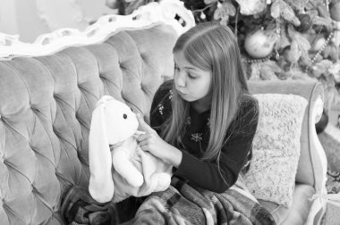 Sessizlik tutun. Küçük kız tavşan oyuncak dudaklarından parmak tutun. Yumuşak oyuncak ile küçük çocuk oyun. Noel ağacı, sevimli tavşan ile küçük kız. Yeni yıl hediyesi küçük çocuk. En iyi Noel oyuncak