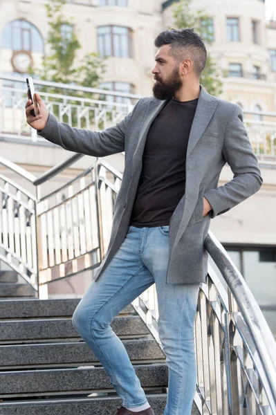 Glad to see you. Man taking selfie photo smartphone urban background. Streaming online video call. Mobile internet. Hipster mobile phone. Blog content. Personal blog. Modern life. Mobile internet