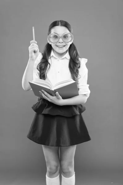 Happy little schoolgirl ready for lesson. Cute child with book. Only wisdom knowing you know nothing. Study foreign language. Study literature. Pupil likes study. Small girl enjoying her school time