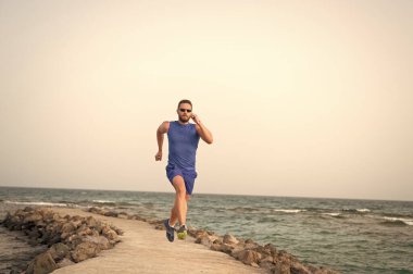 Hızlı koş ya da sonuncu ol. Sahilde koşan adam. Koşucu eğitim açık havada. Fit yaz aylarında erkek spor fitness egzersiz. Koşu sporu ve hobi. Günlük egzersiz büyük sonuç. Erkek profesyonel fitness antrenörü