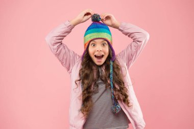 Neşeli bir ruh hali. Modaya uygun bir aksesuar. Sevimli küçük çocuk örülü aksesuar giyiyor. Moda aksesuarları ve pembe geçmişi olan sevimli küçük bir kız. Kış mevsimi için çocuk şapkaları. Aksesuar koruma başı