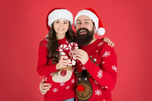 Играть вместе. Посмотри на семью Санта Клауса. Бородатый отец и маленькая девочка. Рождественские игры. Радость и счастье. Рождественская Кэрол. Отец и дочь в рождественских украшениях из конфет. Семейный отдых — стоковое фото