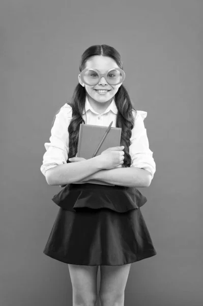 Dies ist mein Buch. Kleinkind mit Notizbuch. Literaturunterricht. Schreiben im Arbeitsbuch. Kinderliteratur. Informationen aus dem Buch. glückliches Schulmädchen in Uniform und Partybrille — Stockfoto