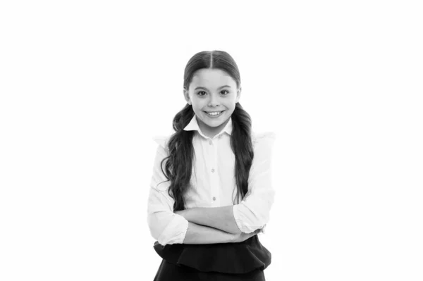 Een Giggling schoolmeisje. Schattig klein schoolmeisje met gelukkige glimlach houden armen gekruist. Klein schoolmeisje op zoek Nice in school uniform. Schattig schoolmeisje met lange brunette haar en charmante look — Stockfoto