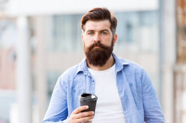 Harika fikirler harika kahveden gelir. Adam kahveyi alıp götürüyor. Sakallı adam dışarıda rahatla. Kahve molası. Kafein bağımlısı. Sabah kahvesi. Olgun hipster sıcak içeceğin tadını çıkar.