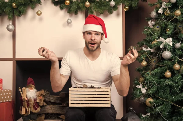 La mañana antes de Navidad. entrega regalos de Navidad. Feliz hombre santo. compras de Navidad en línea. Escena de año nuevo con regalo de árbol. hombre en sombrero de santa celebrar regalo de Navidad. Feliz Navidad. ¿Qué es esto? — Foto de Stock