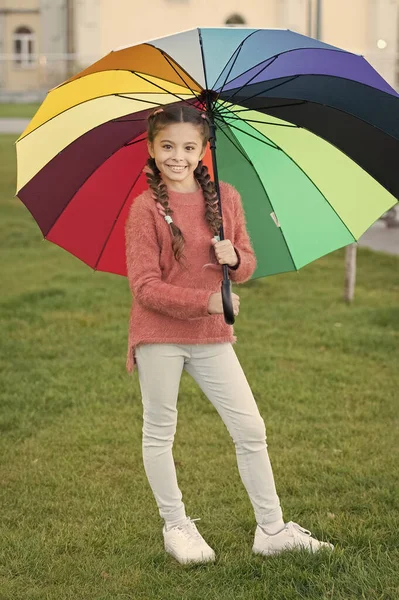 Paraguas multicolor para niña feliz. Humor positivo en el clima lluvioso de otoño. Arco iris después de la lluvia. niño alegre. Paraguas de primavera. Niña sostiene paraguas colorido. Belleza con paraguas — Foto de Stock