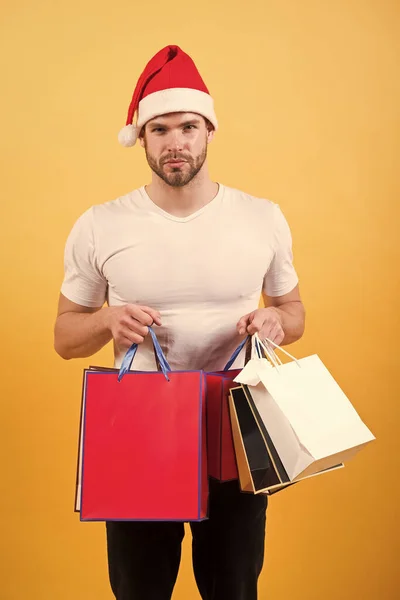 På morgonen innan Xmas. mannen i santa hatt hålla julklapp. leverans julklappar. lycklig santa man på gul bakgrund. Online julhandeln. Gott Nytt År. Christmas sammansättning — Stockfoto