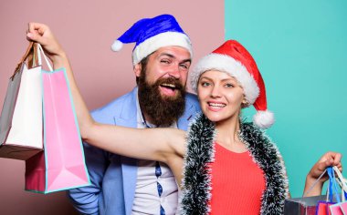 Hediyeleri önceden hazırla. Mutlu noeller. Erkek ve kadın alışverişi. Noel alışverişi. Neşeli Noel Baba şapkaları kağıt torbalar taşır. Hediyeler al. Mutlu yıllar. Aile alışverişi. Kutlamaya katıl