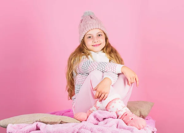 Blijf warm en comfortabel. Warme accessoires die je deze winter gezellig houden. Kid meisje dragen gebreide hoed ontspannende roze achtergrond. Kind lang haar warm wollen hoed genieten van warm. Warmhoudconcept — Stockfoto