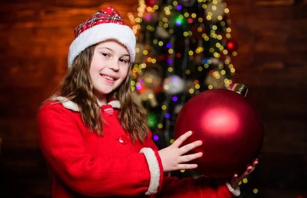 Christmas decorations. Decorate everything around. Sparkling toy. I love decorating christmas tree. Festive atmosphere christmas day. Girl santa claus costume hold big ball christmas tree ornaments — 图库照片