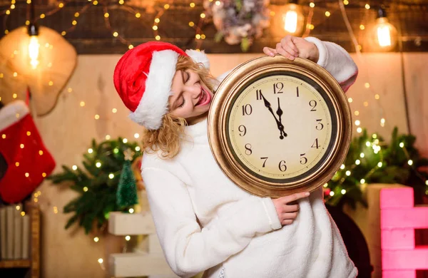 Veselá ženo, je čas oslavovat. Vánoční nálada. Žena s hodinami. dívka v červeném klobouku Santa Clause. Půlnoc. zimní prázdniny. Je čas na Vánoce. Šťastný nový rok. příprava Vánoc — Stock fotografie