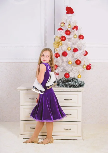 Little girl satisfied christmas gift. Best gift ever. Happy new year concept. Got gift exactly she wanted. Figure skating concept. Dreams come true. Kid near christmas tree hold skates gift — Stock Photo, Image