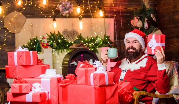 С Новым годом. Рождественские распродажи. Счастливого Рождества. С Новым годом. Красный костюм Санты. Счастливчик пьет чай. Молоко для Санты. бородатый мужчина с настоящей коробкой. xmas presents — стоковое фото
