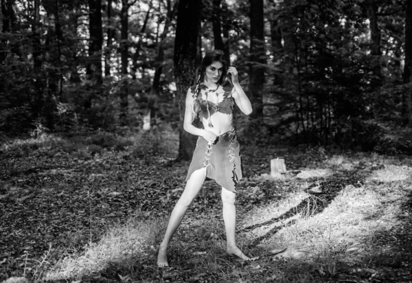 Wild woman in forest. Sexy girl early stage in the evolutionary development. Culture of wild human. Fashion primitive design. Female spirit mythology. Forest fairy. Living wild life untouched nature