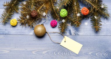 Noel 'i önceden hazırlamak için ipuçları. Kış ve Noel tatili konsepti. Dekoratif balo oyuncağı ve hediye etiketi kopyalama alanı. Noel 'e hazır ol. Noel süslemeleri ahşap arkaplan üstü görünümü